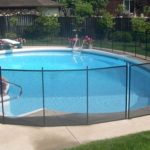 Short black mesh pool fence around pool